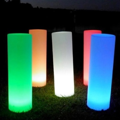 Cinco colunas luminosas coloridas em relva à noite