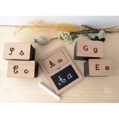 Blocos de madeira com letras cursivas e placa de ardósia com giz