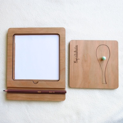 Dois painéis de madeira, um com suporte para papel e lápis, outro com desenho de raquete e palavra 'Empunhadura'