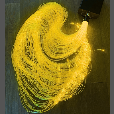 Fibras ópticas iluminadas a amarelo quente num fundo de madeira escura