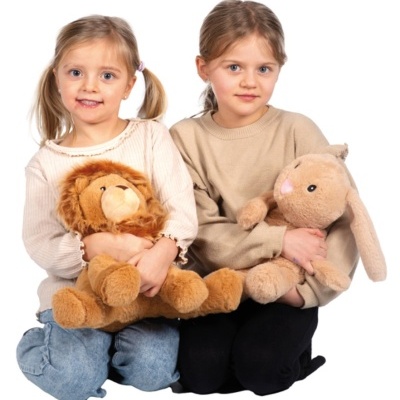 Duas meninas sentadas com peluches de leão e coelha