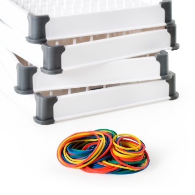 Caixas plásticas brancas com cantos pretos e elásticos coloridos no chão