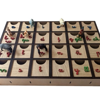 Tabuleiro de madeira com gavetas e figuras de animais e letras coloridas em cima