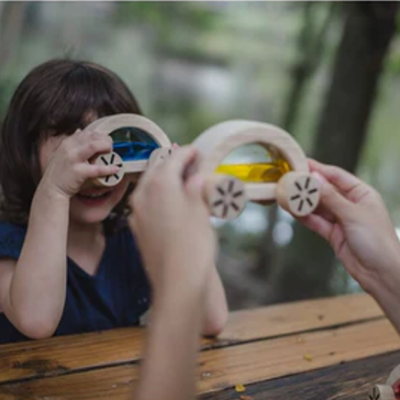 Brinquedos de madeira em forma de carros com janelas coloridas