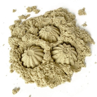 Areia cinzento-bege moldada em formas de conchas sobre fundo branco