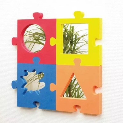 Espelho decorativo de parede com quatro peças coloridas em forma de puzzle e espelhos geométricos