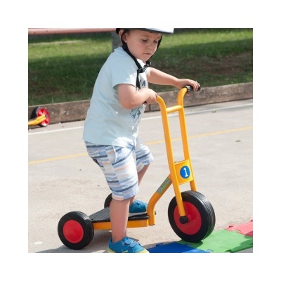 Criança com capacete usando trotinetes amarelo com rodas pretas e vermelhas num parque