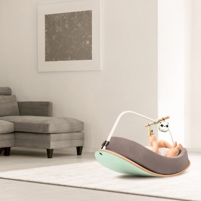 Cadeira de bebé cinza e verde-água com brinquedos, em sala moderna com sofá cinza