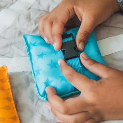 Mãos seguram almofada azul com estrelas e fivela preta