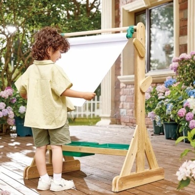 Pintura de cavalete infantil em madeira clara com rolo de papel branco no jardim