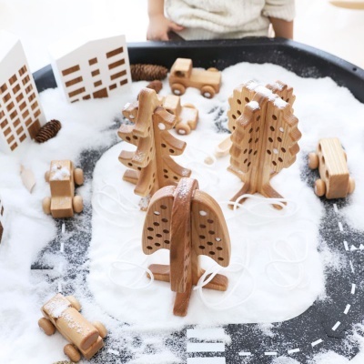 Brinquedos de madeira em miniatura simulando cidade com neve.