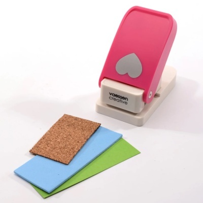 Impressora de carimbos roxa e bege com três pedaços de materiais azul, verde e cortiça