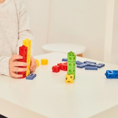 Blocos de empilhar coloridos com dado numa superfície branca