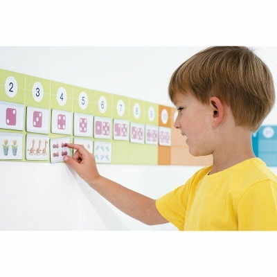 Menino a colocar cartões educativos numerados na parede