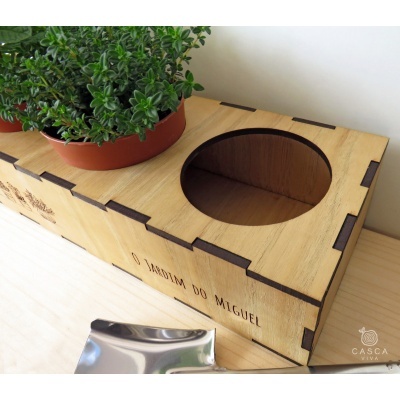 Caixa de madeira com planta artificial verde