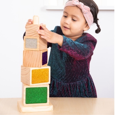 Criança a empilhar blocos de madeira coloridos brilhantes