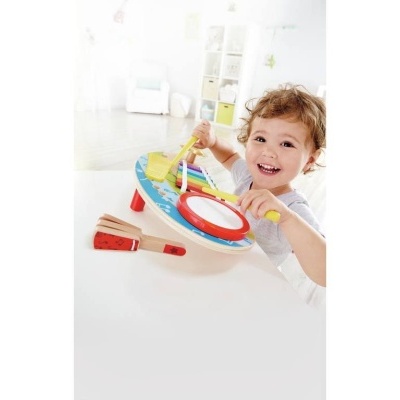 Criança a brincar com tambor infantil de madeira colorido