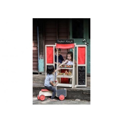 Banca de venda de brinquedo em madeira branca com detalhes vermelhos e placa SUPER FRESH com crianças a brincar