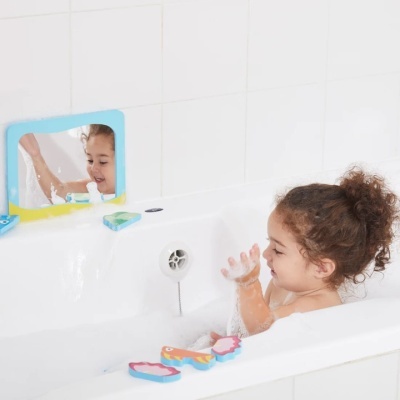 Criança na banheira com espelho e brinquedos de espuma coloridos