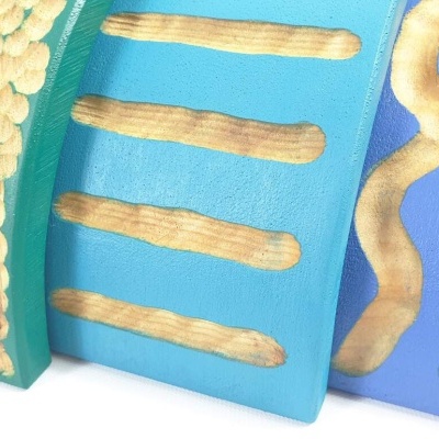 Três placas com texturas e padrões em relevo, cores azul e verde com detalhes amarelos.