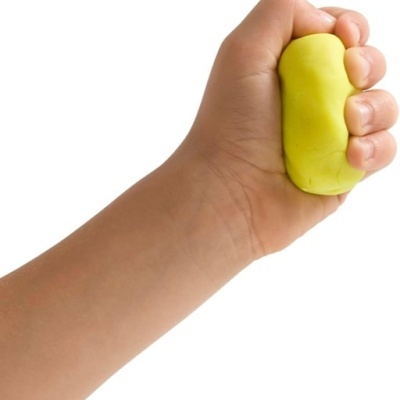 Mão humana a segurar bola de massa amarela em fundo branco