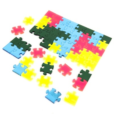 Peças de puzzle coloridas de plástico montadas e soltas sobre fundo branco
