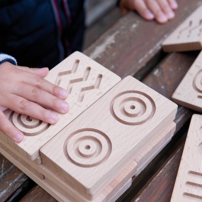 Blocos de madeira com padrões em relevo nas mãos de criança