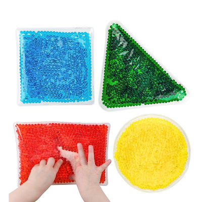Quatro almofadas sensoriais de gel coloridas com diferentes formas e mãos de criança a tocar uma delas