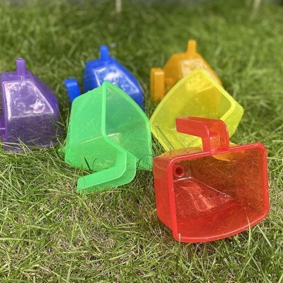 Pequenos baldes plásticos coloridos sobre relva