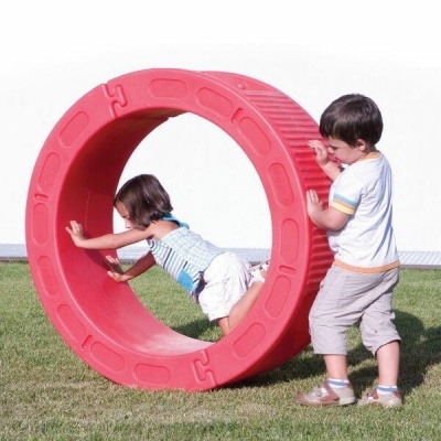 Crianças a brincar com brinquedo circular de plástico vermelho ao ar livre