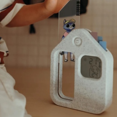 Relógio digital em forma de casa com termómetro e ilustração de gato azul