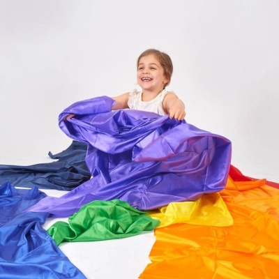 Menina com pano colorido tipo arco-íris em fundo branco