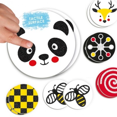 Sete círculos de cartão com padrões coloridos e texturas táteis, incluindo panda, veado, abelhas, e padrões geométricos.