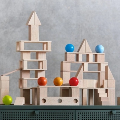 Blocos de madeira empilhados formando estruturas com bolas coloridas