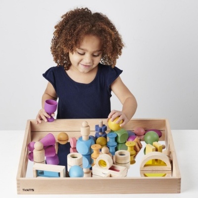 Criança a brincar com peças de madeira coloridas numa caixa de madeira