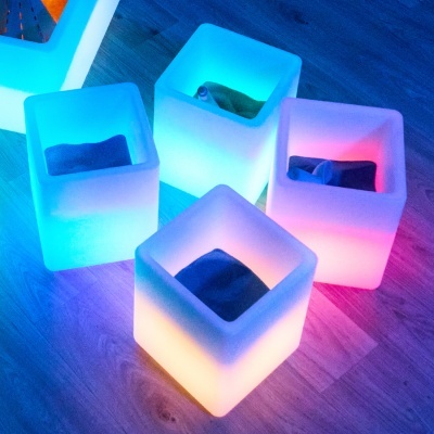 Quatro puffs quadrados iluminados com almofadas no interior