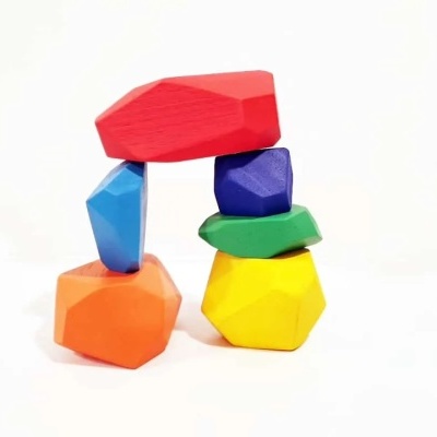 Blocos de madeira coloridos empilhados com fundo branco.