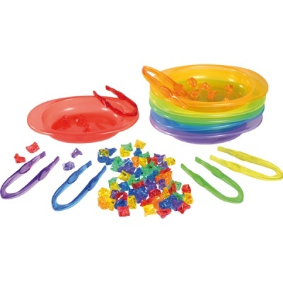 Conjunto de pratos plásticos coloridos com pinças e peças pequenas coloridas.