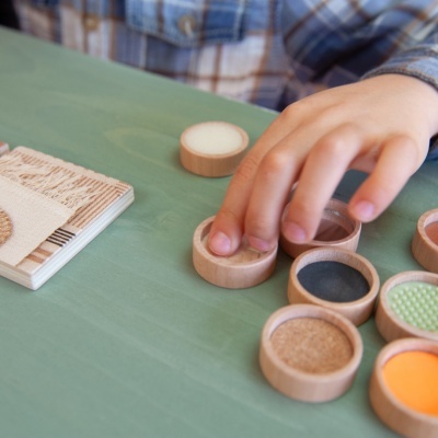 Peças redondas de madeira coloridas e texturizadas em mesa verde