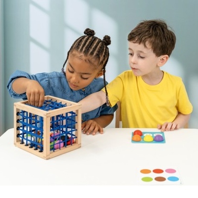 Crianças brincando com brinquedo educativo de madeira colorido numa mesa branca