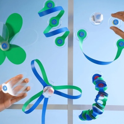 Dispositivos rotativos com ventosas azuis e verdes numa superfície transparente