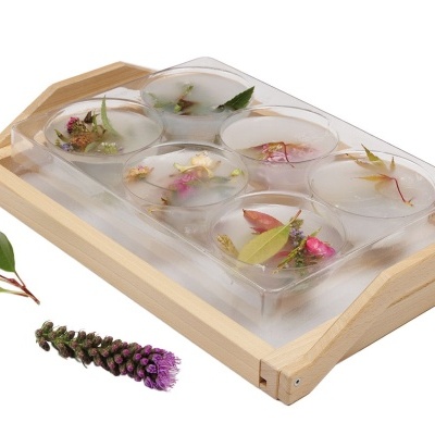 Bandeja de madeira com velas decoradas com flores e folhas secas