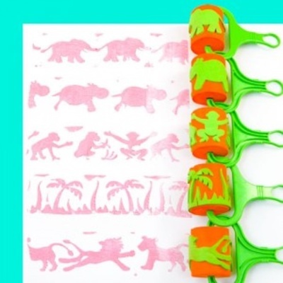 Carimbos verdes com padrões de animais e paisagem em cerdas laranjas a criar impressões cor-de-rosa numa folha branca.