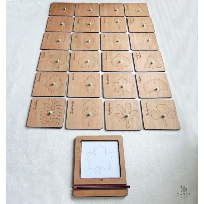 Peças de madeira com desenhos de folhas e pinos verdes, moldura de madeira com desenho de folha