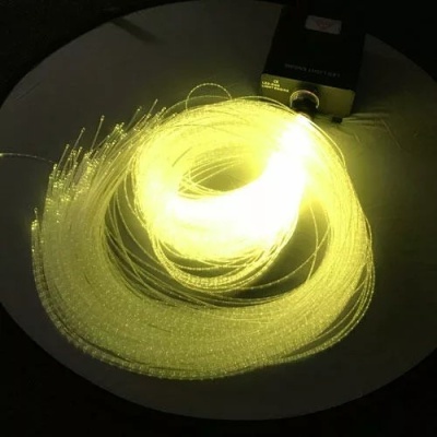 Fio de fibra ótica iluminado com dispositivo preto numa superfície redonda