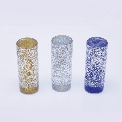 Três tubos cilíndricos transparentes com glitter dourado, prateado e azul