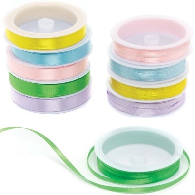 Oito rolos de fita de cetim coloridas, com uma fita verde desenrolada