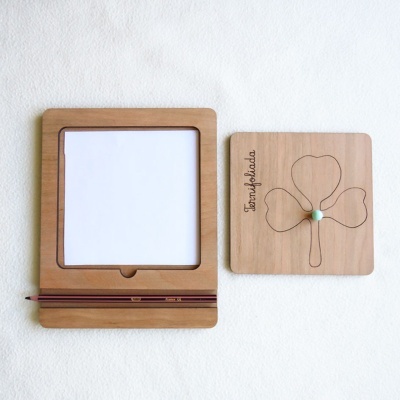 Quadros em madeira clara com papel para desenho e símbolo de trevo de quatro folhas gravado