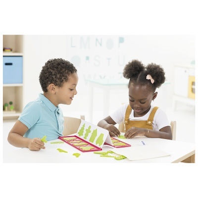 Crianças jogando com cartas coloridas de dinossauros numa mesa branca