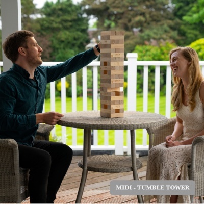 Jogo de torre de blocos de madeira natural empilhados em mesa redonda de vime cinza com base metálica